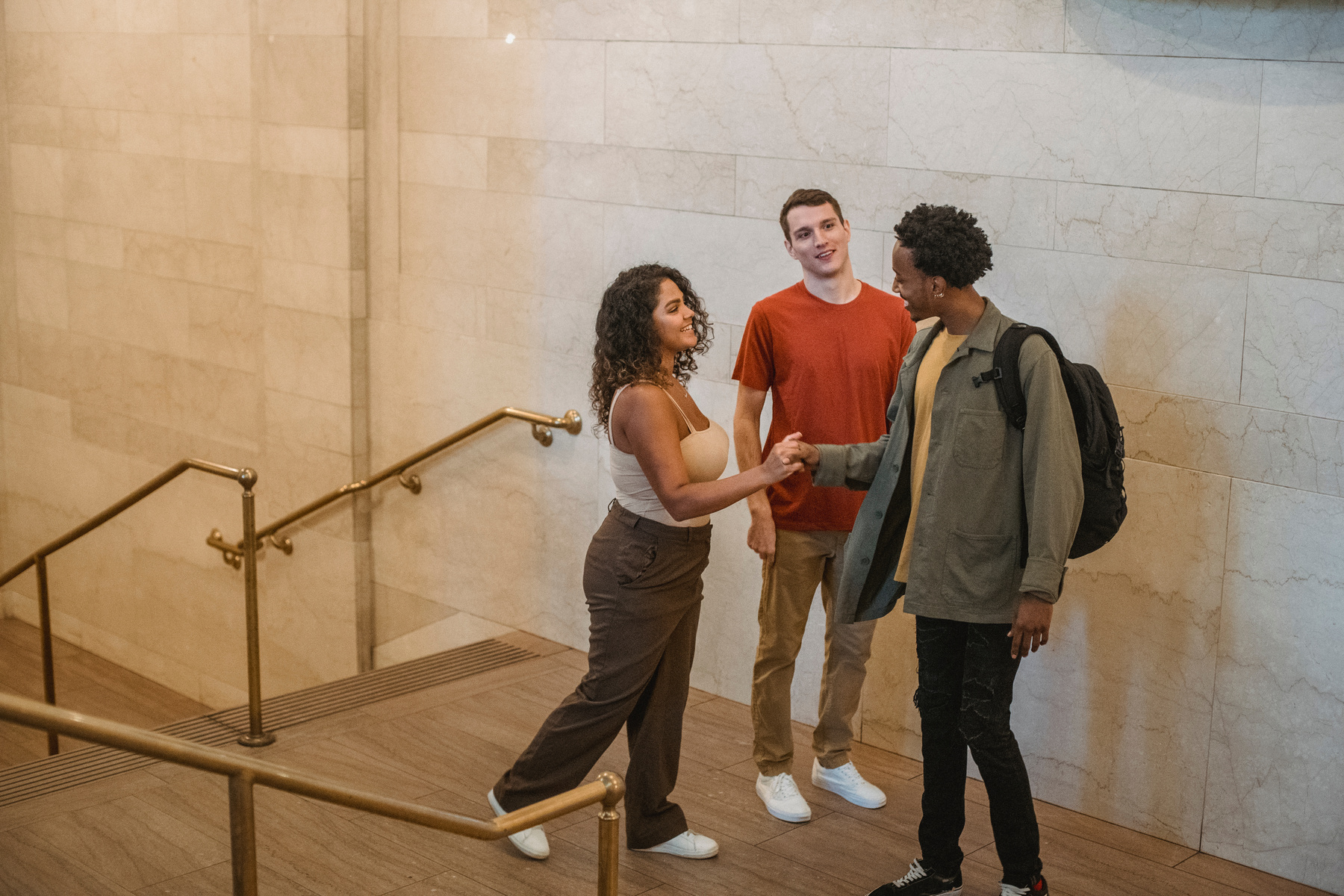 Cheerful multiracial friends communicating in hallway